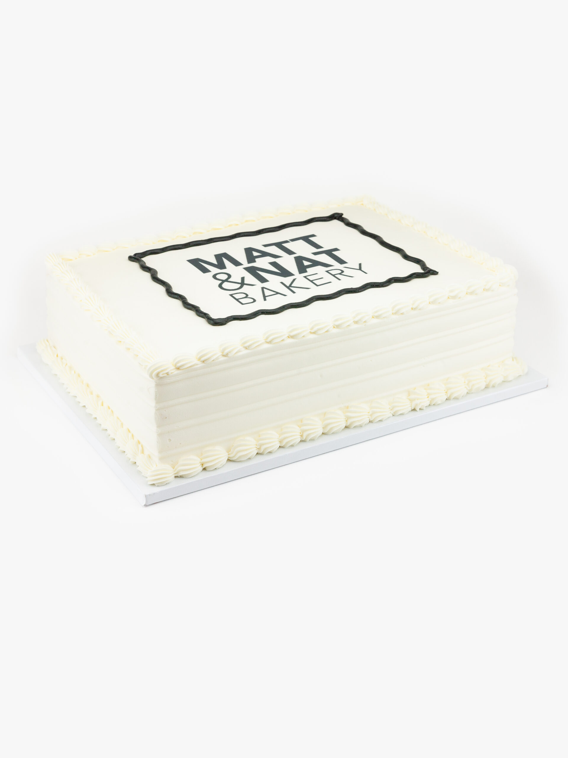 A Single Celebration Cake in Quarter Sheet Size with Matt & Nat Bakery Logo on a light grey background