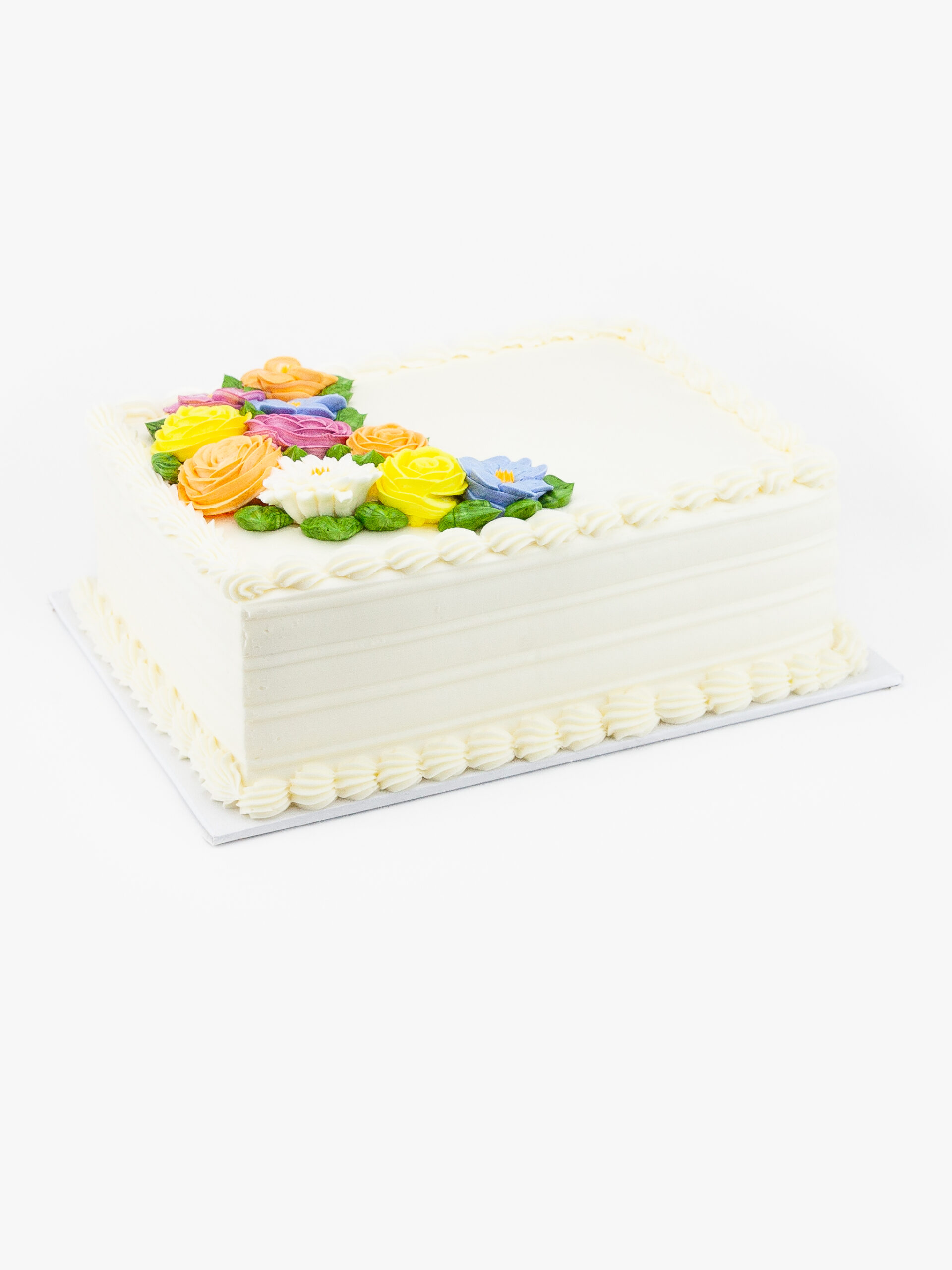 A Single Celebration Cake in Quarter Sheet Size decorated with flower icing on a light grey background