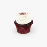 A Single Regular Red Velvet Dessert Cupcake in wrapping on a light grey background