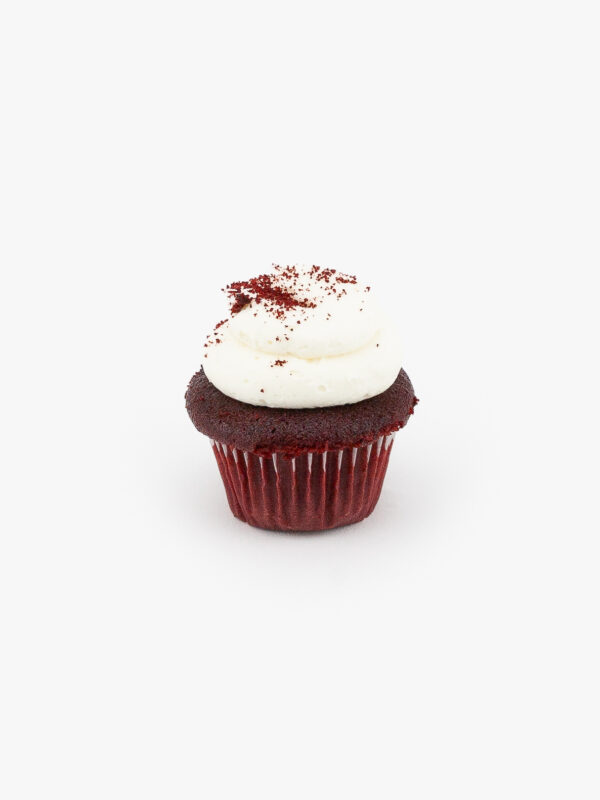 A Single Mini Red Velvet Dessert Cupcake in wrapping on a light grey background