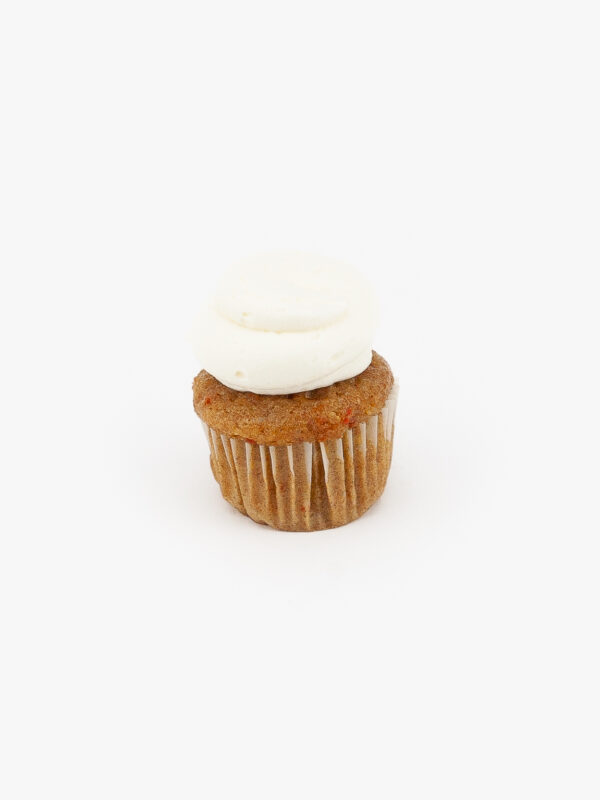 A Single Mini Carrot Dessert Cupcake in wrapping on a light grey background