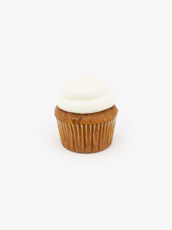 A Single Regular Carrot Dessert Cupcake in wrapping on a light grey background