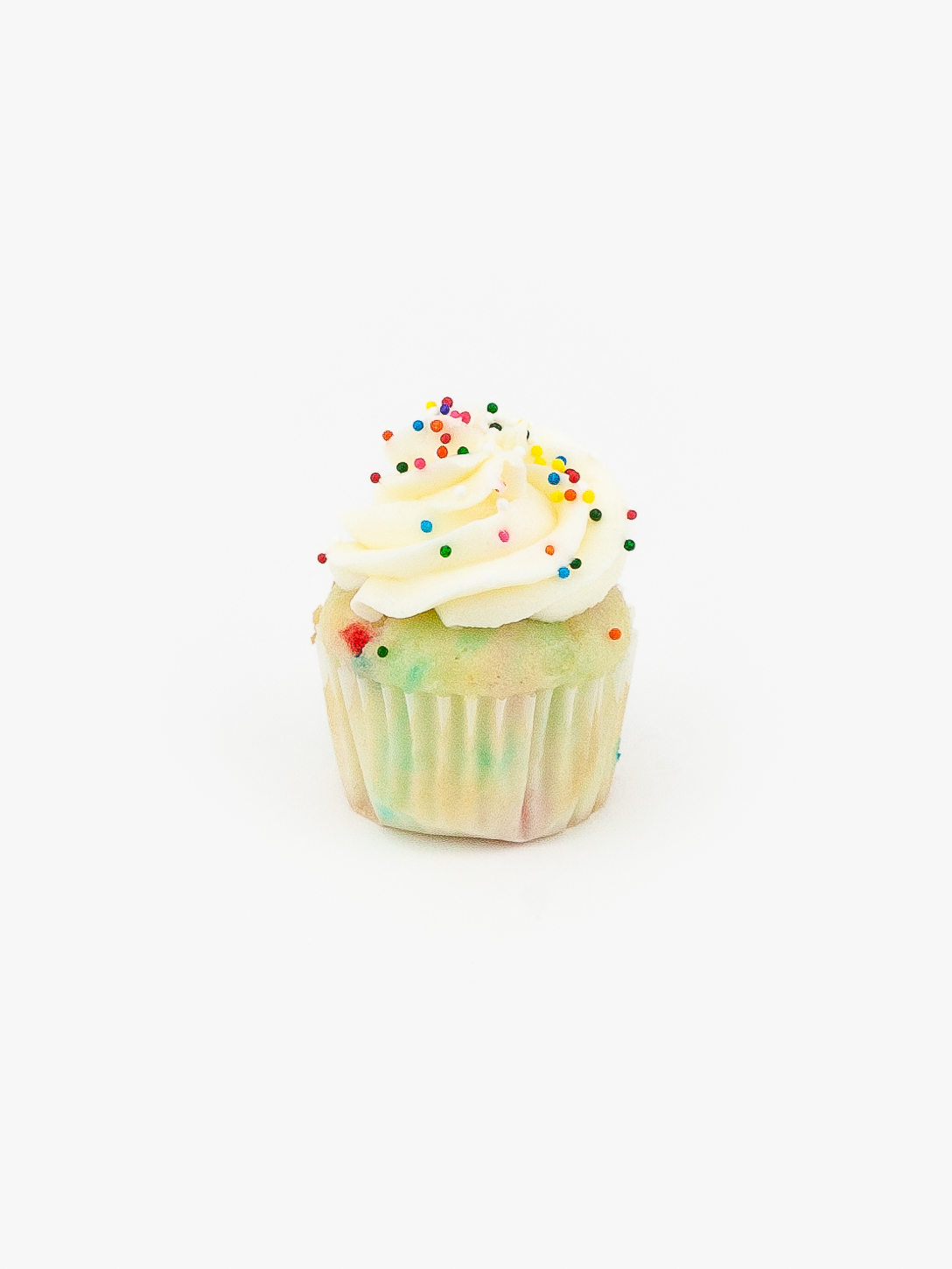 A Single Mini Confetti Dessert Cupcake in wrapping on a light grey background