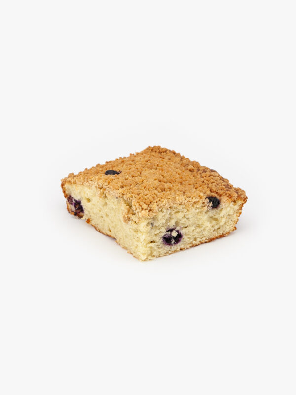 A Single Piece of Blueberry Crumb Cake Cut on a light grey background