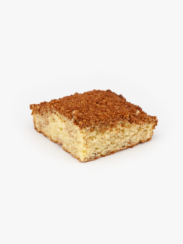 A Single Piece of Cinnamon Crumb Cake Cut on a light grey background