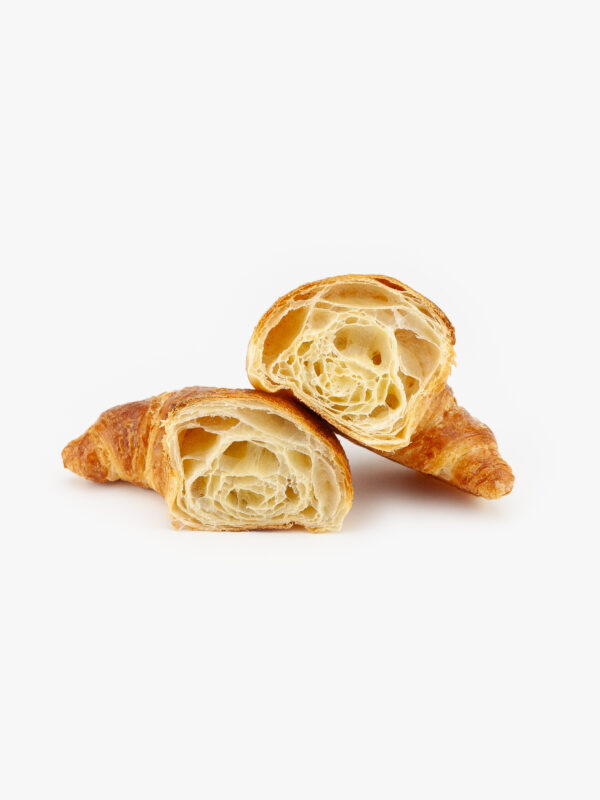 A Single Curved Jumbo Butter Breakfast Croissant Cut Open on a light grey background