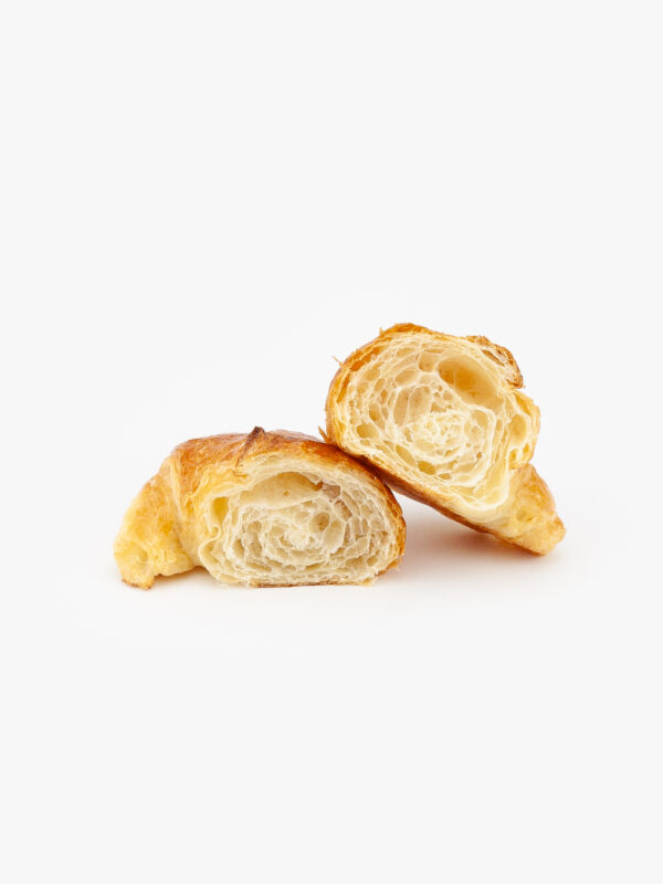 A Single Curved Mini Butter Croissant Cut Open on a light grey background