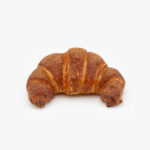 A Single Curved Jumbo Churro Breakfast Croissant on a light grey background