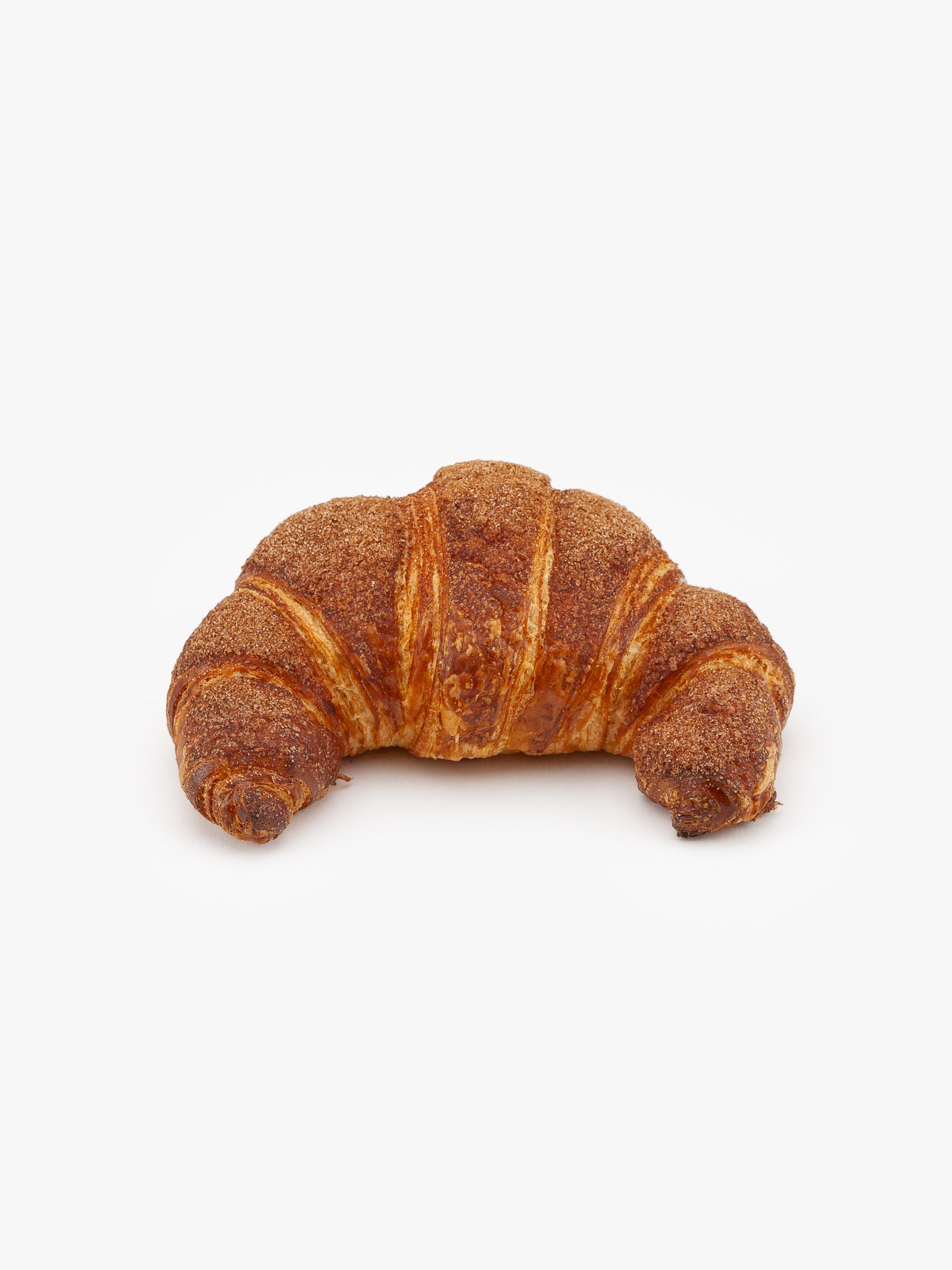 A Single Curved Jumbo Churro Breakfast Croissant on a light grey background