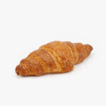 A Single Straight Jumbo Butter Breakfast Croissant on a light grey background