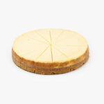 A Single 10" Round New York 14 Cut Cheesecake individually sectioned on a light grey background