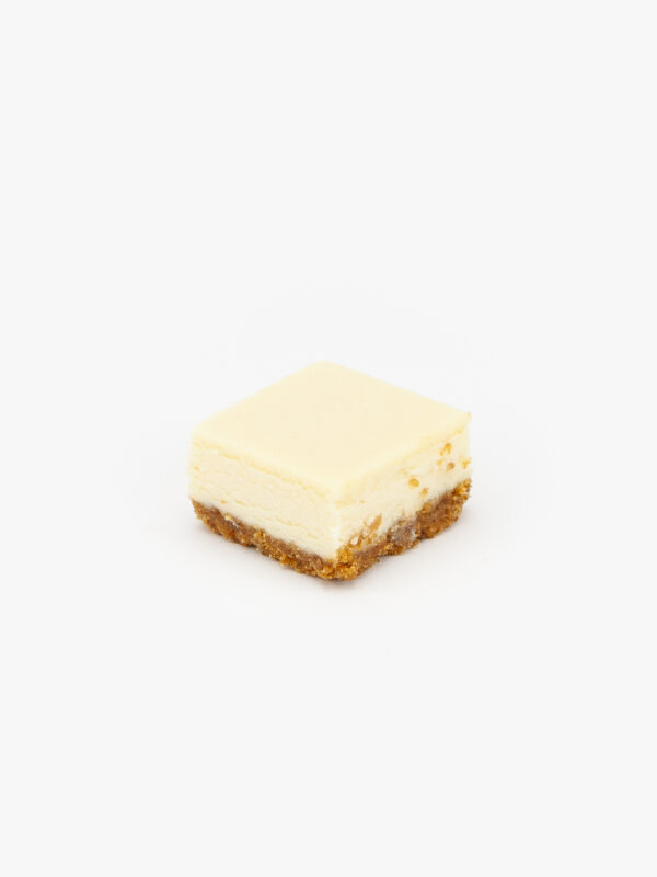 A single cut of New York Cheesecake from a Half Sheet 48 cut on a light grey background