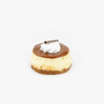 A Single 3" Individual Round Dulce De Leche Cheesecake on a light grey background