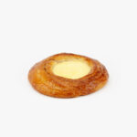 A Jumbo Round Custard Breakfast Danish perfectly baked on a light grey background