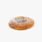 A Single Jumbo Round Dulce De Leche Danish with icing sugar on a light grey background