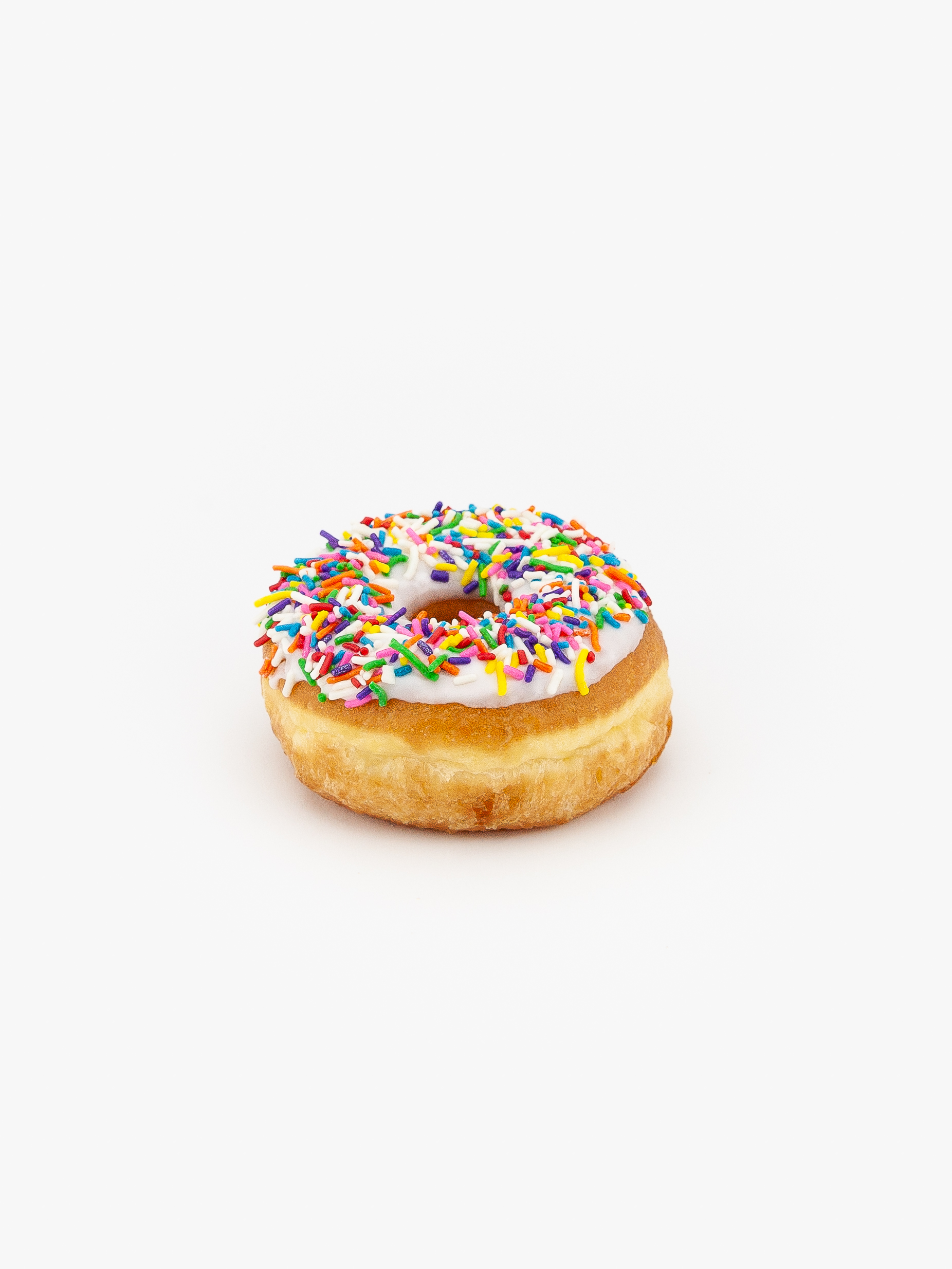 A Regular Raised Sprinkle Donut on a light grey background