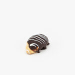 A Single Eclair Mini Dessert Pastry on a light grey background