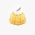 A Single 3" Vanilla Bundt Cake Dessert Pastry with icing on a light grey background