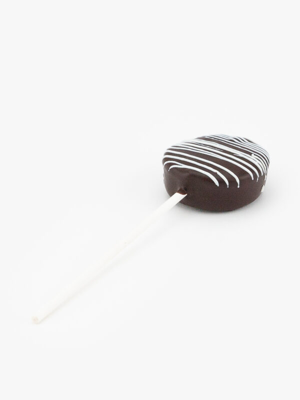 A Single Chocolate Cake Puck Dessert Pastry On a Stick on a light grey background