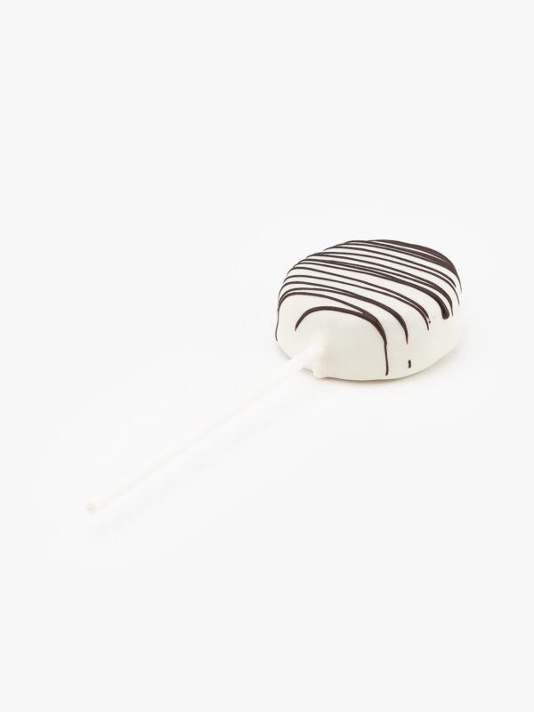 A Single White Cake Puck Dessert Pastry On a Stick on a light grey background