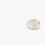 A Single Red Velvet Cake Puck Dessert Pastry On a Stick on a light grey background