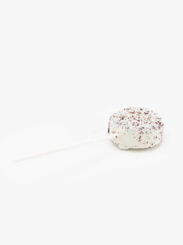 A Single Red Velvet Cake Puck Dessert Pastry On a Stick on a light grey background