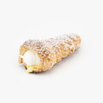 A Single Custard Cream Regular Horn Dessert Pastry with icing sugar on a light grey background