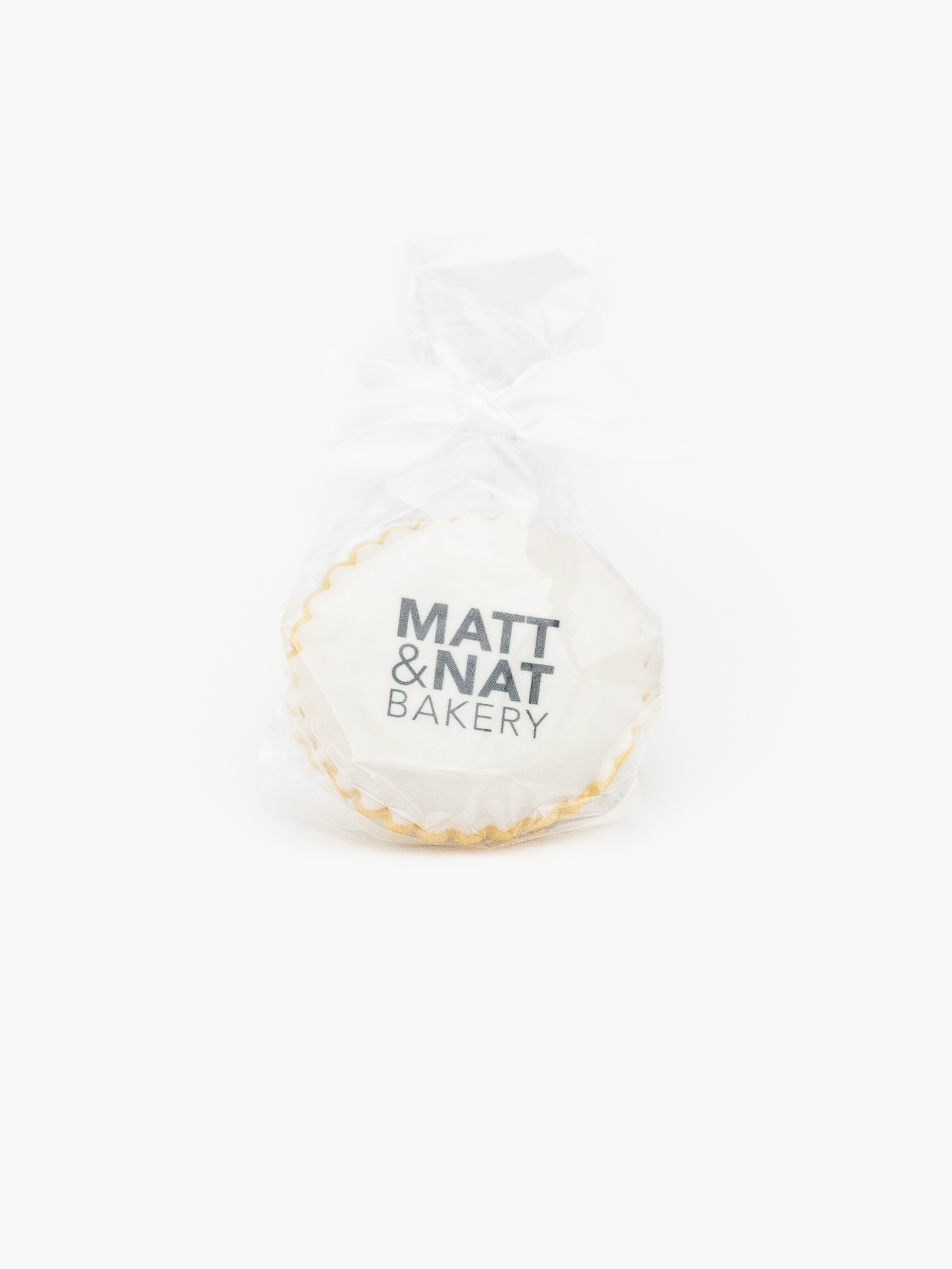 An Individually Wrapped Bag with Custom printed Cookie and White Twist Tie on a light grey background