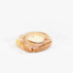 A Single Individual Wrapped Jumbo Cheese Danish Sealed in Plastic on a light grey background