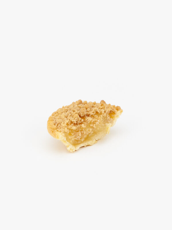 A Mini Baked Apple Crumble Pie Sliced open on a light grey background