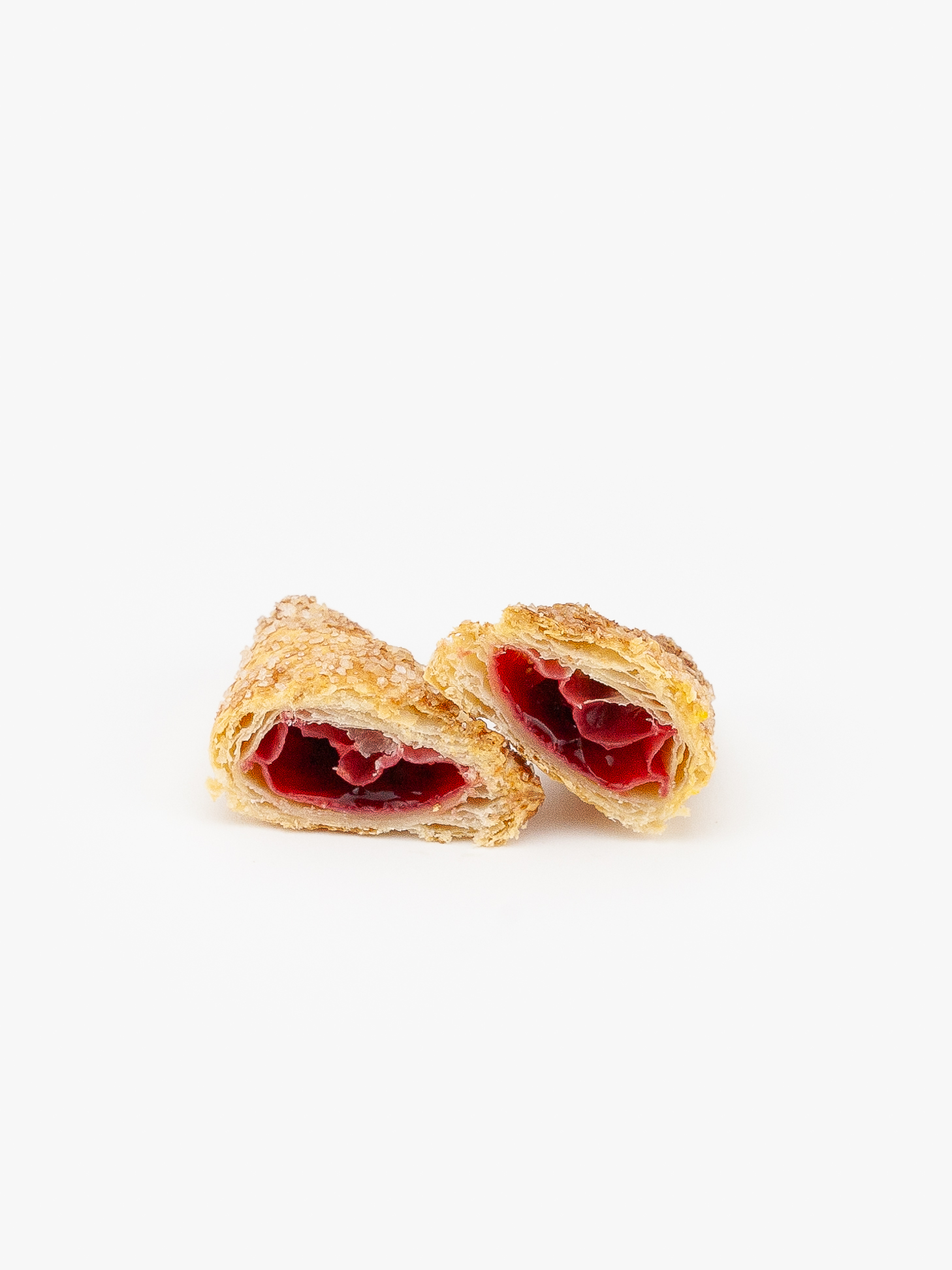 An Assorted Mini Cherry Puff Pastry cut open on a light grey background