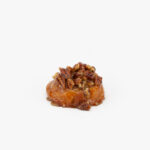 A Mini Sticky Pecan Breakfast Sweet Roll on a light grey background