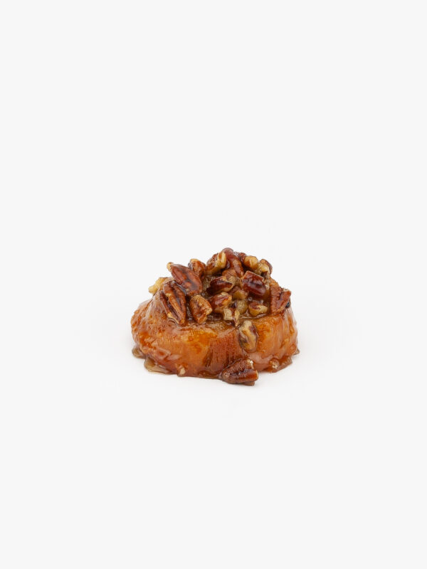 A Mini Sticky Pecan Breakfast Sweet Roll on a light grey background