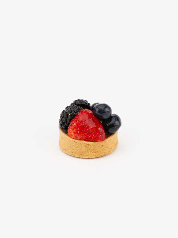 A Fresh Mixed Berry Mini Dessert Tart on light grey background