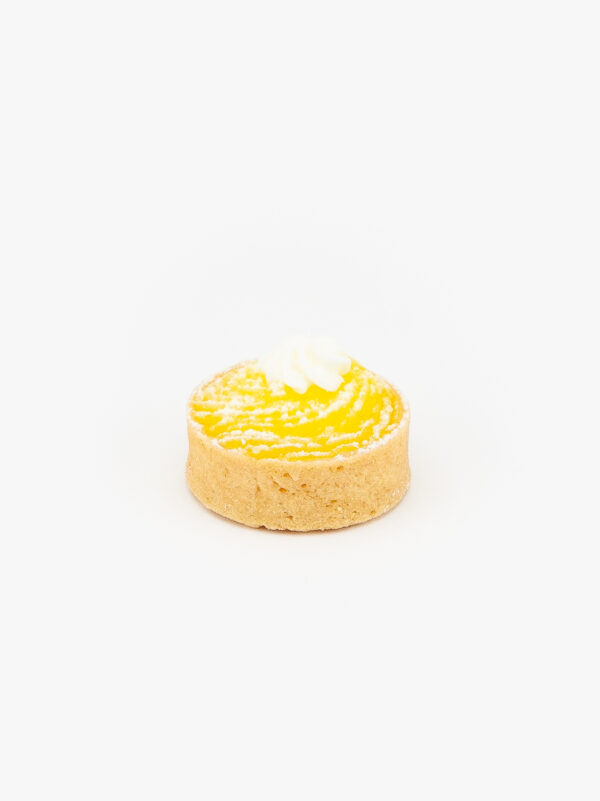 A Lemon Mini Dessert Tart on light grey background