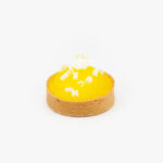 A Lemon Individual Dessert Tart on a light grey background.