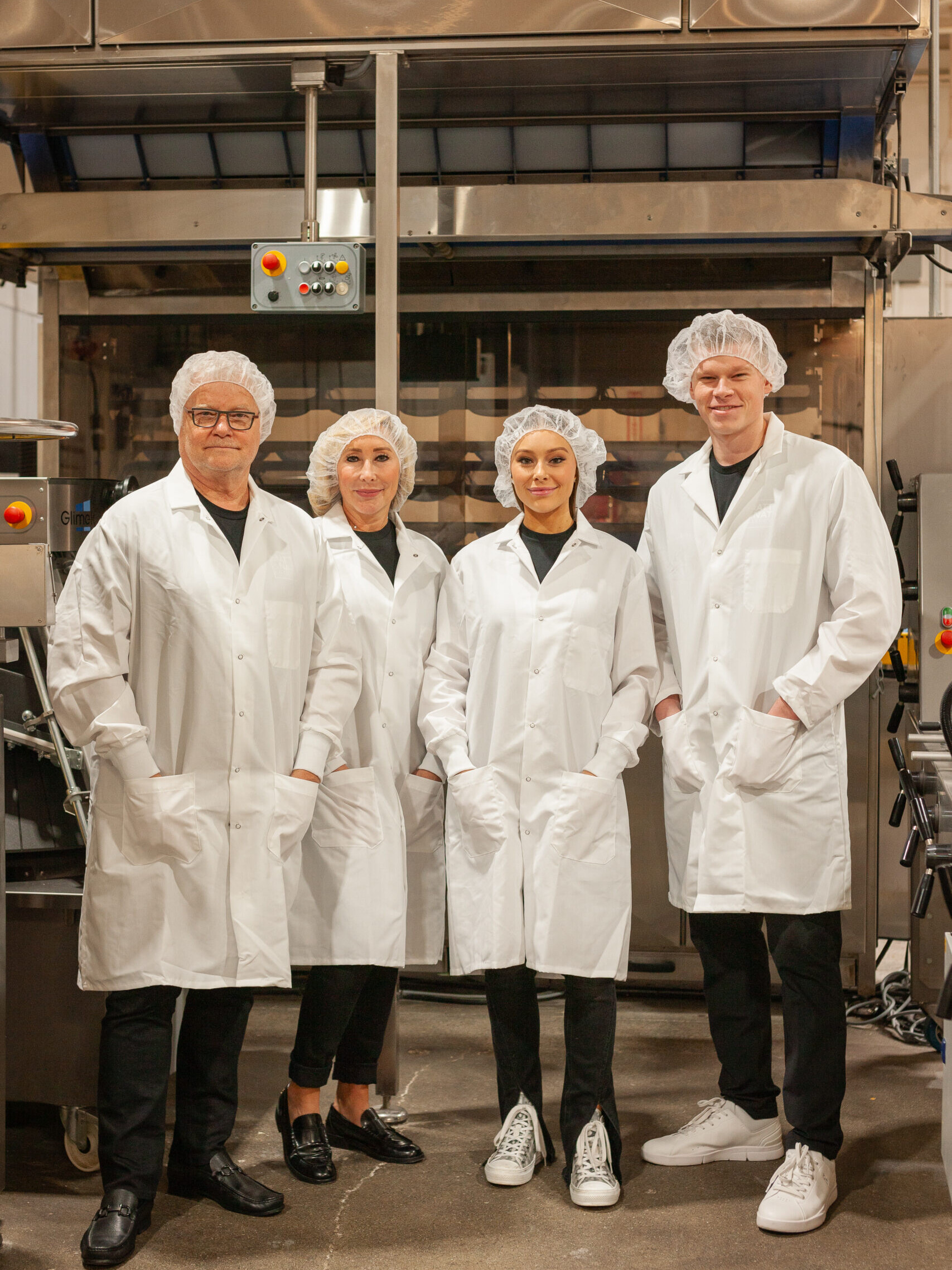 color picture of the Kleijn family, owners of Matt & Nat Bakery Group LP pictured with white coats and hair nets with production equipment in the background